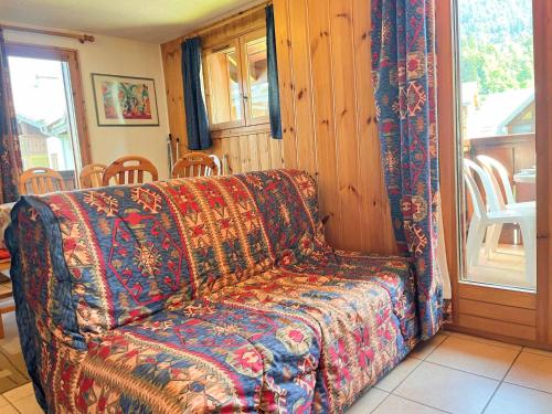 - un canapé installé dans un salon à côté d'une fenêtre dans l'établissement Appartement T2 au centre de Samoëns avec balcon, parking et accès navette ski. - FR-1-624-20, à Samoëns