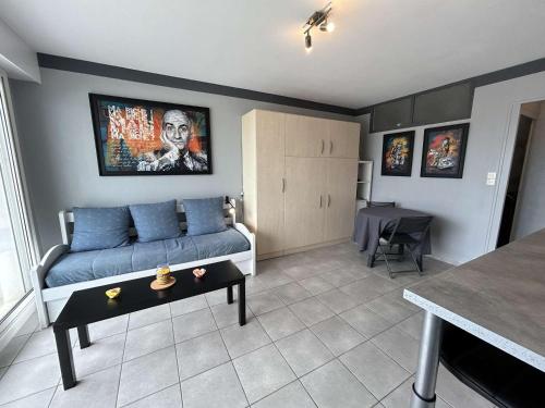 un salon avec un canapé bleu et une table dans l'établissement Studio cabine 4 pers. avec balcon et parking, proche plage - FR-1-224C-176, à Saint-Jean-de-Monts