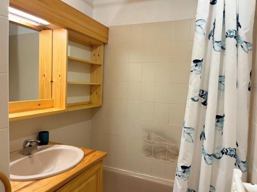 une salle de bain avec un lavabo et un rideau de douche dans l'établissement Appartement T2 cosy avec jardinet, proche centre et skibus, WiFi, parking et équipements complets - FR-1-624-61, à Samoëns