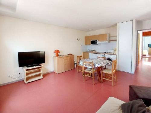 un salon avec une table et une cuisine dans l'établissement Appartement à Cauterets: 4 pers, parking, proche thermes - FR-1-812-86, à Cauterets