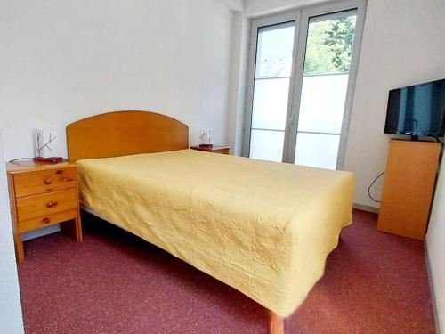 - une chambre avec un lit, une commode et une télévision dans l'établissement Appartement à Cauterets: 4 pers, parking, proche thermes - FR-1-812-86, à Cauterets