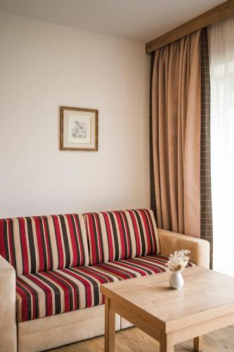 a living room with a couch and a coffee table at Hotel Nussbaumerhof *** in Rodengo