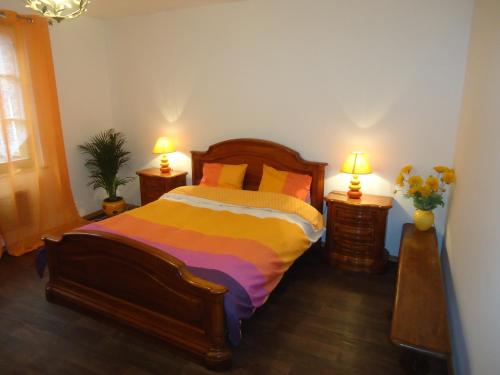 1 dormitorio con 1 cama con 2 lámparas y flores en La Tour Enchantée, en Ribeauvillé