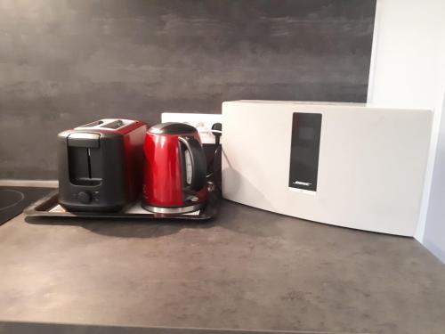 un grille-pain rouge et noir et une boîte sur un comptoir dans l'établissement Cozy new studio central close Eiffel tower, à Paris