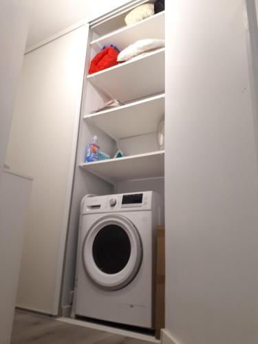 - une buanderie avec un lave-linge et des étagères dans l'établissement Cozy new studio central close Eiffel tower, à Paris