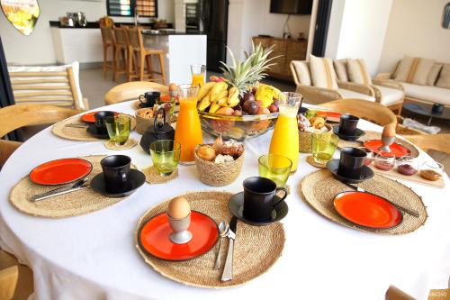 a table with plates and bowls of food on it at Villa Kintana - Piscine - SPA - Prestations 5 Etoiles in Petite Île