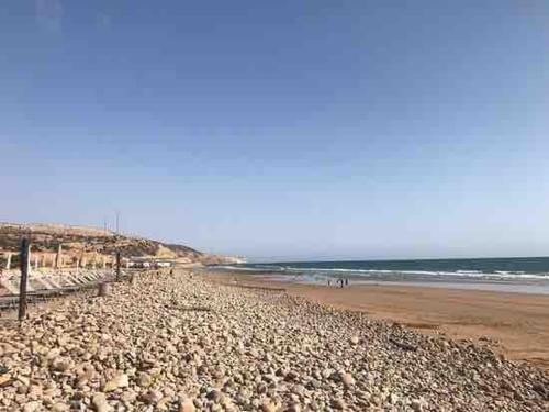 a beach with rocks and the ocean in the background at Valley House Imi Ouaddar in Imi Ouaddar