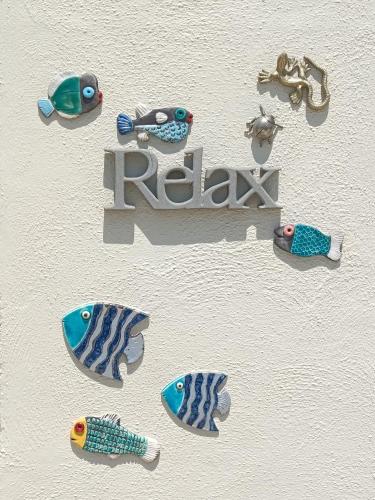 a white wall with a sign with fish on it at Three Cities Apartments in Cospicua