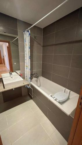 a bathroom with a tub and a toilet and a sink at Appartement moderne équipé, situé au centre de Oujda in Oujda