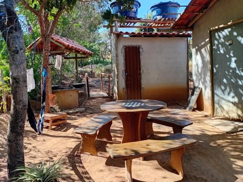 eine Terrasse mit einem Tisch und 2 Bänken in der Unterkunft Camping dos oliveira in Jaboticatubas