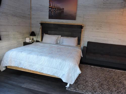 a bedroom with a large bed with a wooden wall at Gite Passion et Tendresse B&B in Shefford