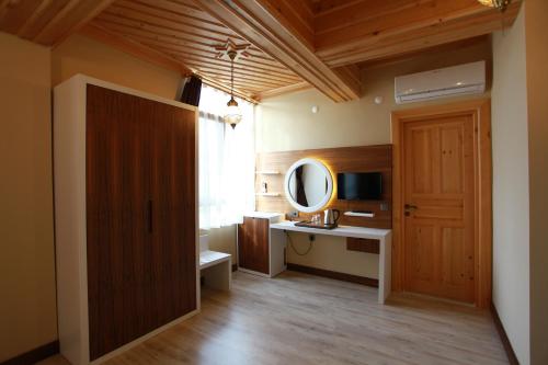 Habitación con puerta, escritorio y espejo. en Bacchus Pension en Antalya