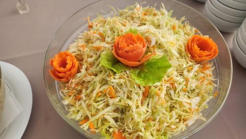 a glass bowl of food with carrots and cabbage at Hotel Carpați in Predeal