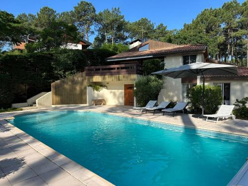 une piscine devant une maison dans l'établissement Villa Lou Lan, à Biscarrosse