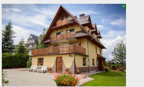 a large house with a balcony on top of it at Domek u Socków in Zakopane