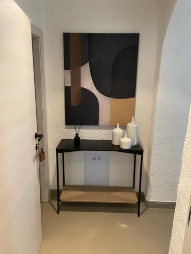 a table with two vases and a painting on a wall at Agriturismo Tenuta la Marchesa in Novi Ligure