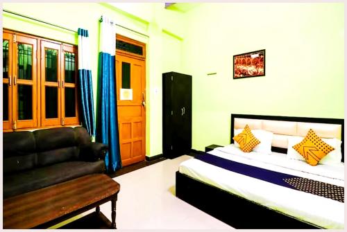a bedroom with a bed and a couch at VARANASI HOTEL H R GUEST HOUSE Near Kasi Visawanath Temple & Ganga Ghat - #Free Wi-Fi #Room service #Parking #Fully Air conditioning #Premium Room In Varanasi in Varanasi