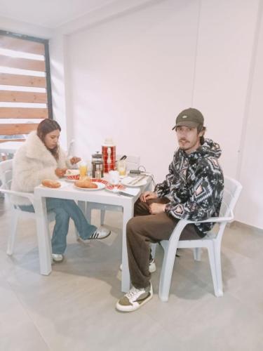 two people sitting at a table eating food at Mmarros Inn in Cusco
