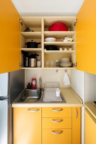 - une cuisine avec des placards jaunes et un évier dans l'établissement STUDIO 4 COUCHAGES - À 2 min de la plage à pied - Parking et linge en option, à Juan-les-Pins