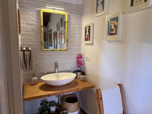 a bathroom with a sink and a mirror at AU-RA Vegan B&B in Castagneto Carducci