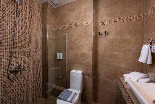 a bathroom with a shower and a toilet and a sink at Heaven Hotel Thessaloniki Airport in Néon Rýsion