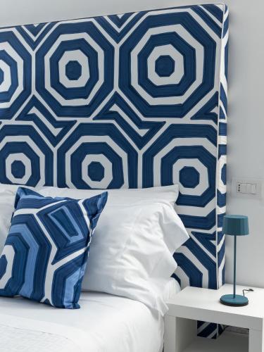 a bed with a blue and white patterned headboard at Hotel San Michele in Anacapri