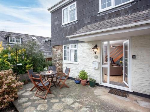 a patio with a table and chairs in front of a house at Garden Cottage in Kingsbridge