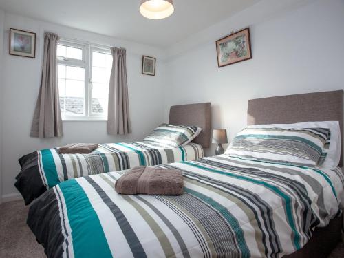 two beds sitting next to each other in a bedroom at Garden Cottage in Kingsbridge