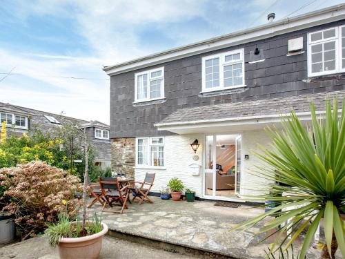 a house with a patio with a table and chairs at Garden Cottage in Kingsbridge