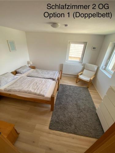 a bedroom with a bed and a chair and a window at Michelles FeWo in Uttenweiler