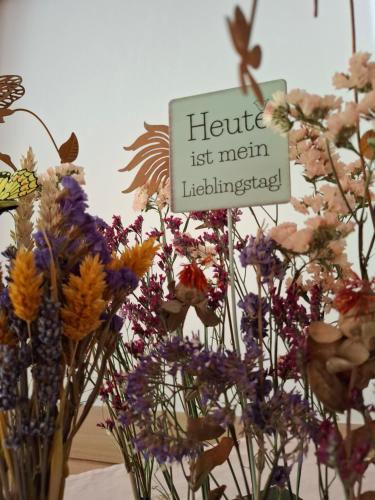 a vase filled with flowers with a sign that reads hello main intelligence at Ferienhäuser Thalbach in Heiligenblut