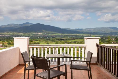 a table and chairs on a balcony with mountains at Heaven Hotel Thessaloniki Airport in Néon Rýsion