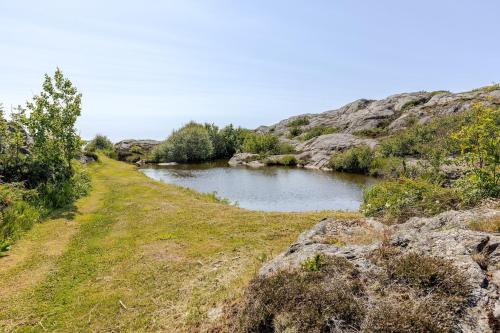 a river in the middle of a field with rocks at Family Home - Coastal Calmness in Stockevik in Skärhamn