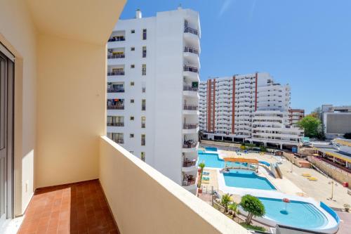 a balcony with a view of a pool and buildings at Squash Club Apartamentos in Portimão