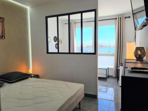 une chambre avec un lit et une grande fenêtre dans l'établissement Studio Cap d'Agde, 4 couchages, proche port et commerces, à 500m du centre - FR-1-249-408, au Cap d'Agde