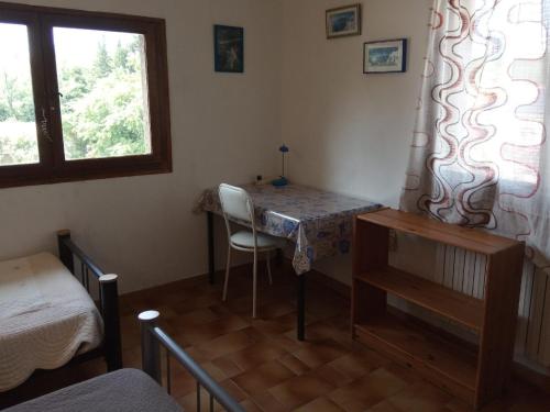 Cette chambre comprend une table avec une chaise et une fenêtre. dans l'établissement CHAMBRE lumineuse jardin arboré, à Montpellier