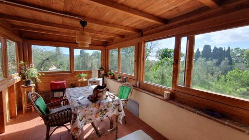 a dining room with a table and some windows at AU-RA Vegan B&B in Castagneto Carducci