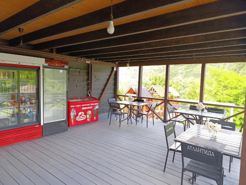 an outdoor deck with tables and chairs and a cooler at Family House in Makarovka