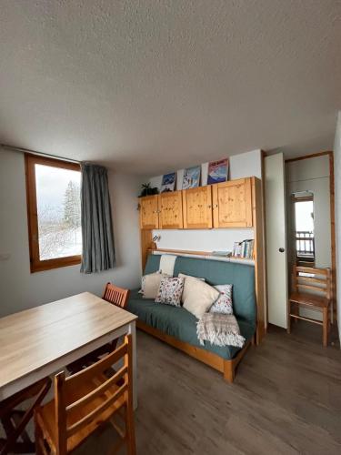 un salon avec un canapé et un lit dans l'établissement Appartement Montchavin - accès direct piscine et remontées mécaniques, à La Plagne Tarentaise