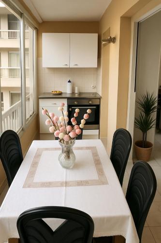 une cuisine avec une table et un vase de fleurs roses dans l'établissement STUDIO 4 COUCHAGES - À 12 min de la plage à pied - Wifi inclus - parking et linge en option, à Antibes