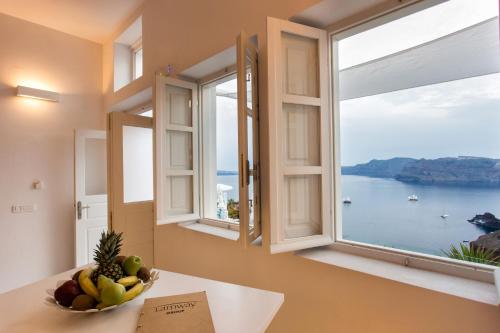 a bowl of fruit on a table in front of a window at Armeni Village in Oia