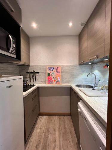 une cuisine avec un évier et un comptoir dans l'établissement Appartement Montchavin - accès direct piscine et remontées mécaniques, à La Plagne Tarentaise