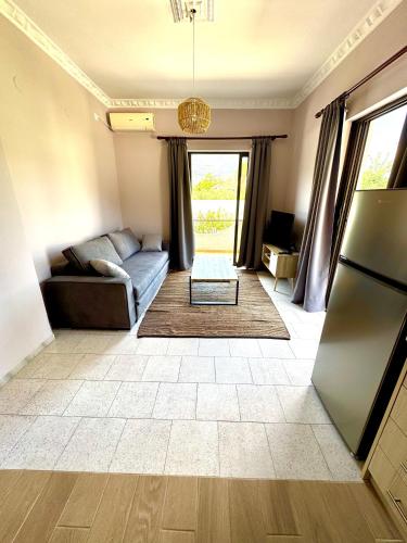 a living room with a couch and a refrigerator at AMMOS FAMILY APARTMENTS in Vasiliki