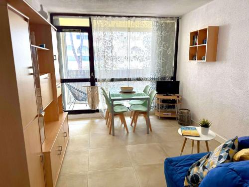 un salon avec une table et un canapé bleu dans l'établissement Studio Cabine Centre-Ville, Parking & Animaux Acceptés - FR-1-307-274, à La Grande Motte