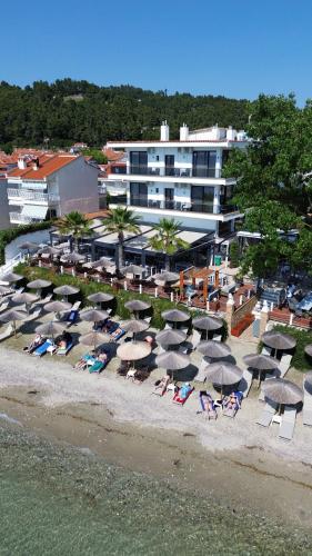 a group of chairs and umbrellas on a beach at EVLOGIA HOTEL SEAFRONT and ANEX by Greek Pride in Fourka