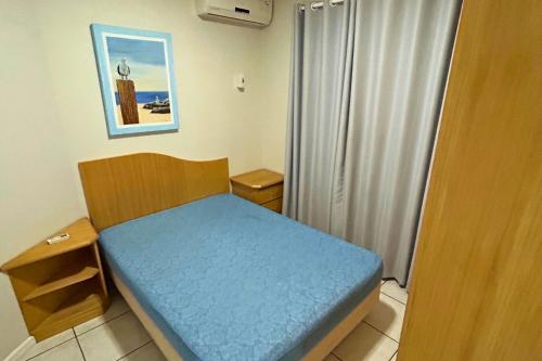 a small bedroom with a blue bed in a room at Apartamento com vista mar e excelente localização in Bombinhas