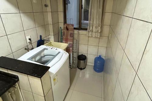 a small kitchen with a washing machine in the corner at Apartamento com vista mar e excelente localização in Bombinhas