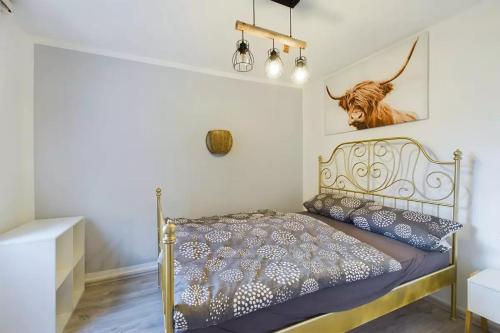 a bedroom with a bed with a picture of a cow on the wall at Haus Ewald in Enkirch