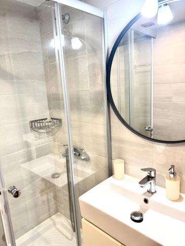 a bathroom with a shower and a sink and a mirror at AMMOS FAMILY APARTMENTS in Vasiliki