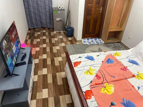 a bedroom with a bed with a comforter with flowers on it at Chambre Moderne in Yaoundé